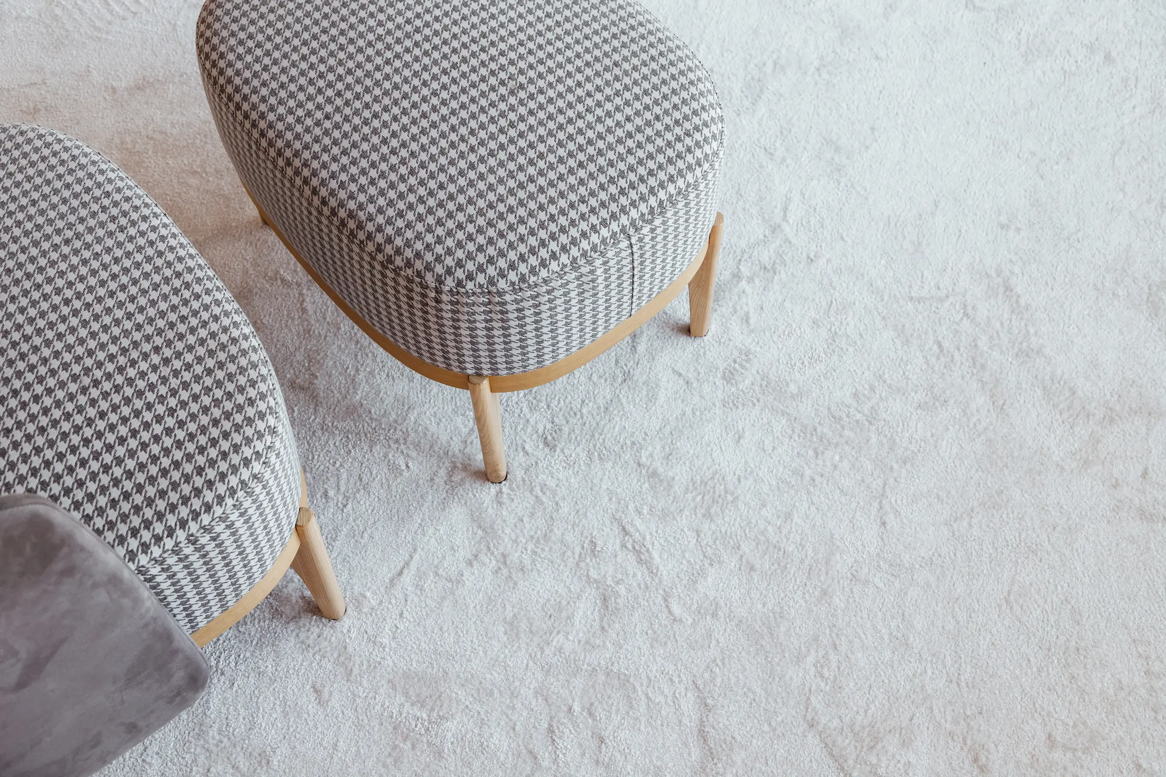 Checkered armchair with bench on wooden legs on a