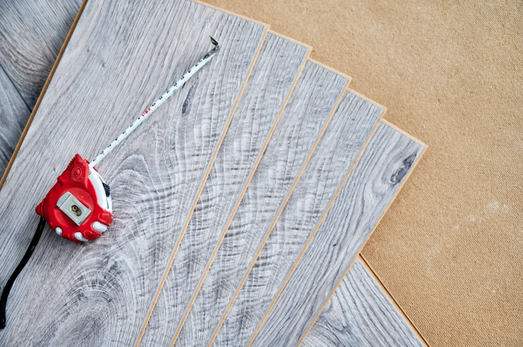 New gray laminate flooring and a red tape measure