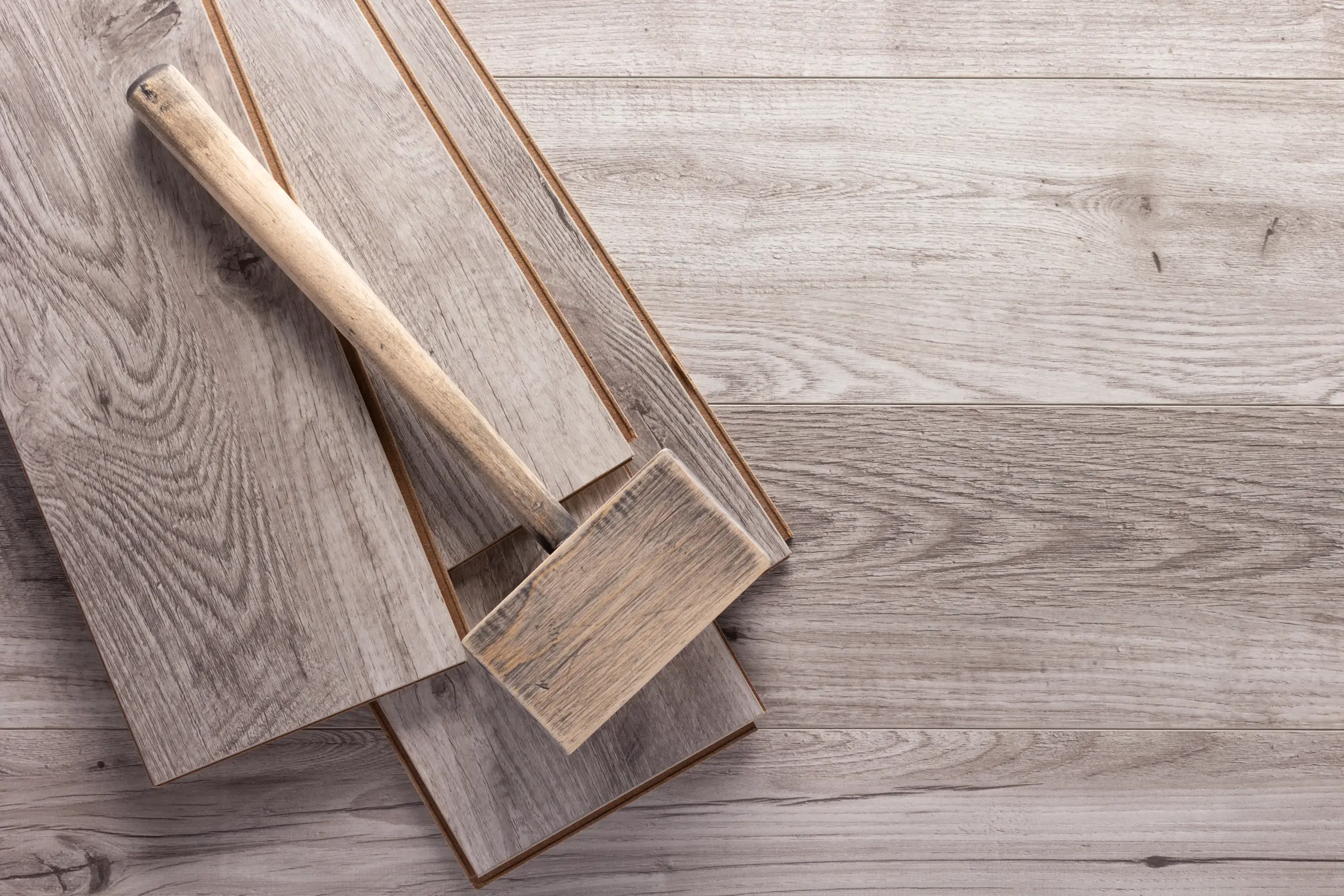 Wooden laminate flooring installation with hammeri